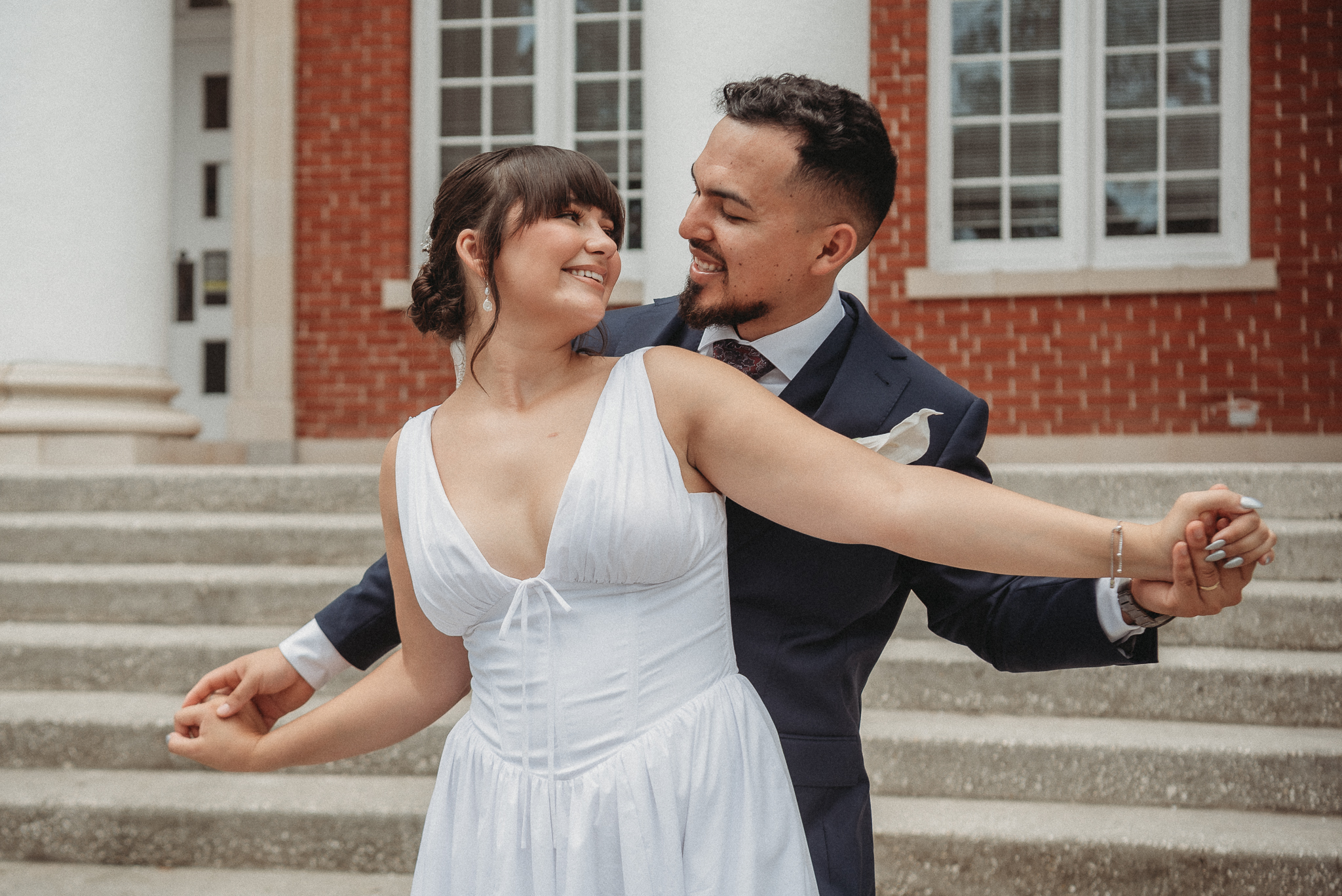 Bride and groom embracing on the steps of the Brooksville Courthouse