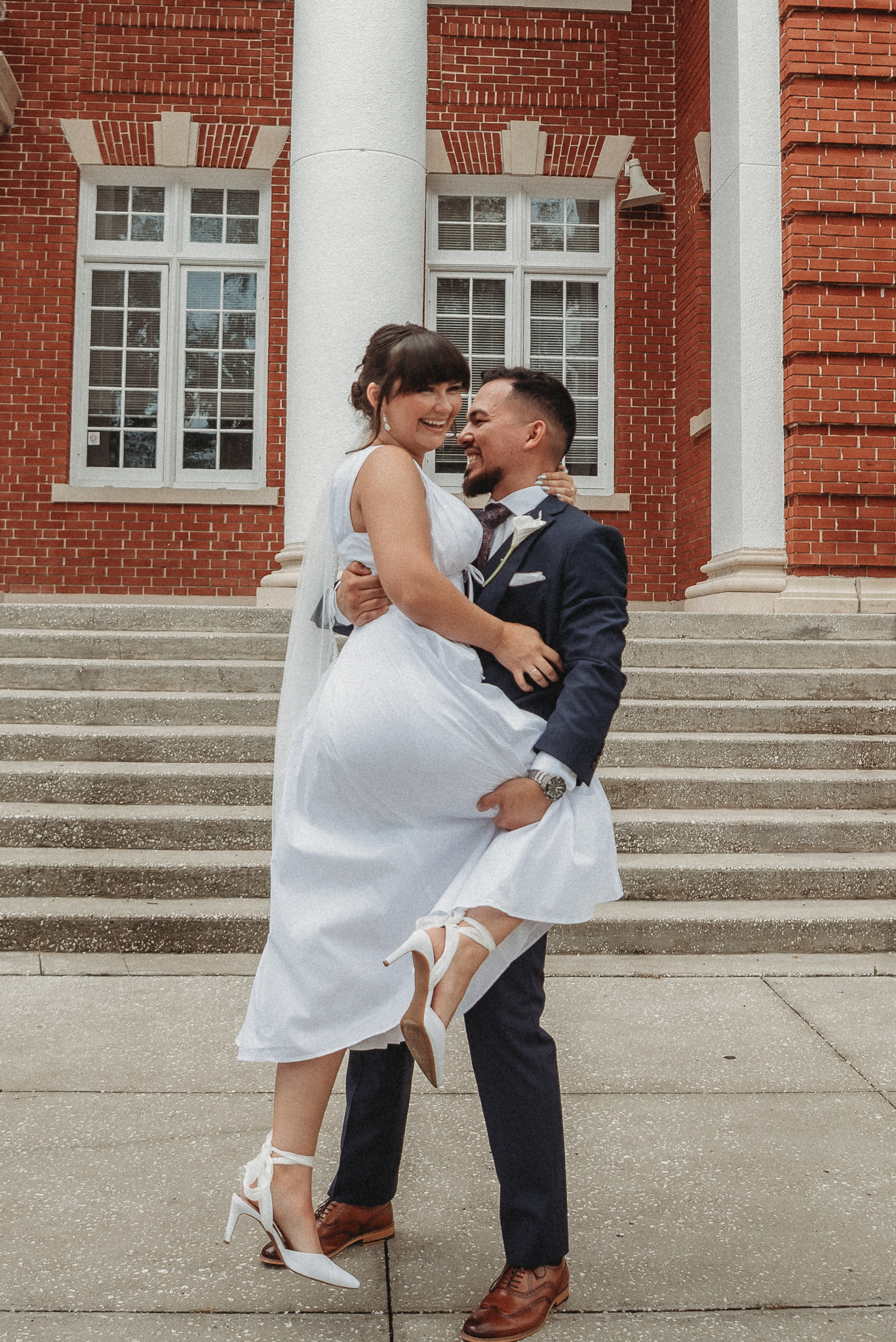 Bride and groom embracing on the steps of the Brooksville Courthouse