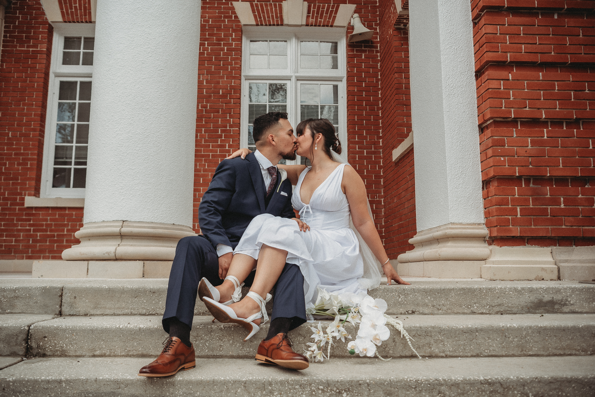 Bride and groom embracing on the steps of the Brooksville Courthouse