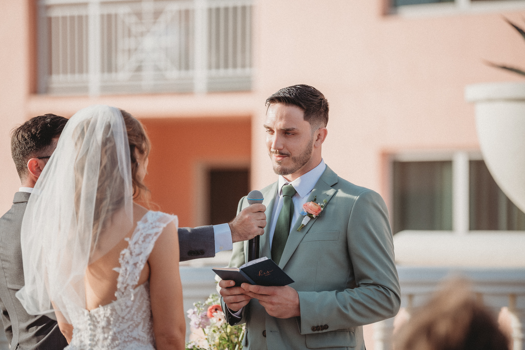 Bride and groom exchanging personal vows with ocean backdrop