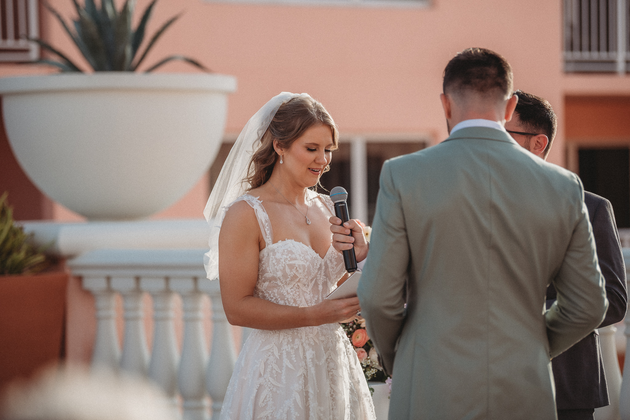 Bride and groom exchanging personal vows with ocean backdrop