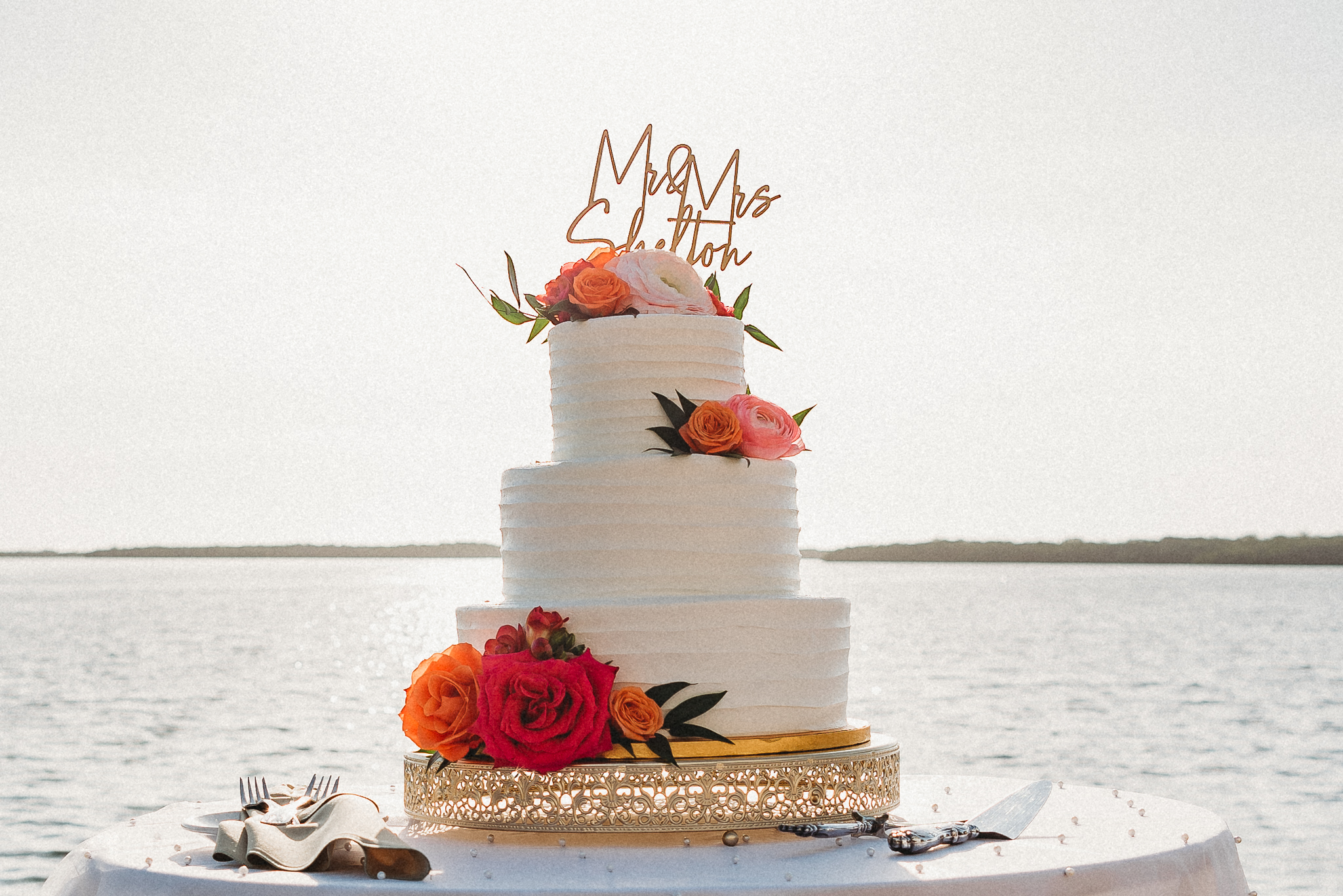 Elegant waterfront wedding cake with vibrant floral details on Florida’s Gulf Coast
