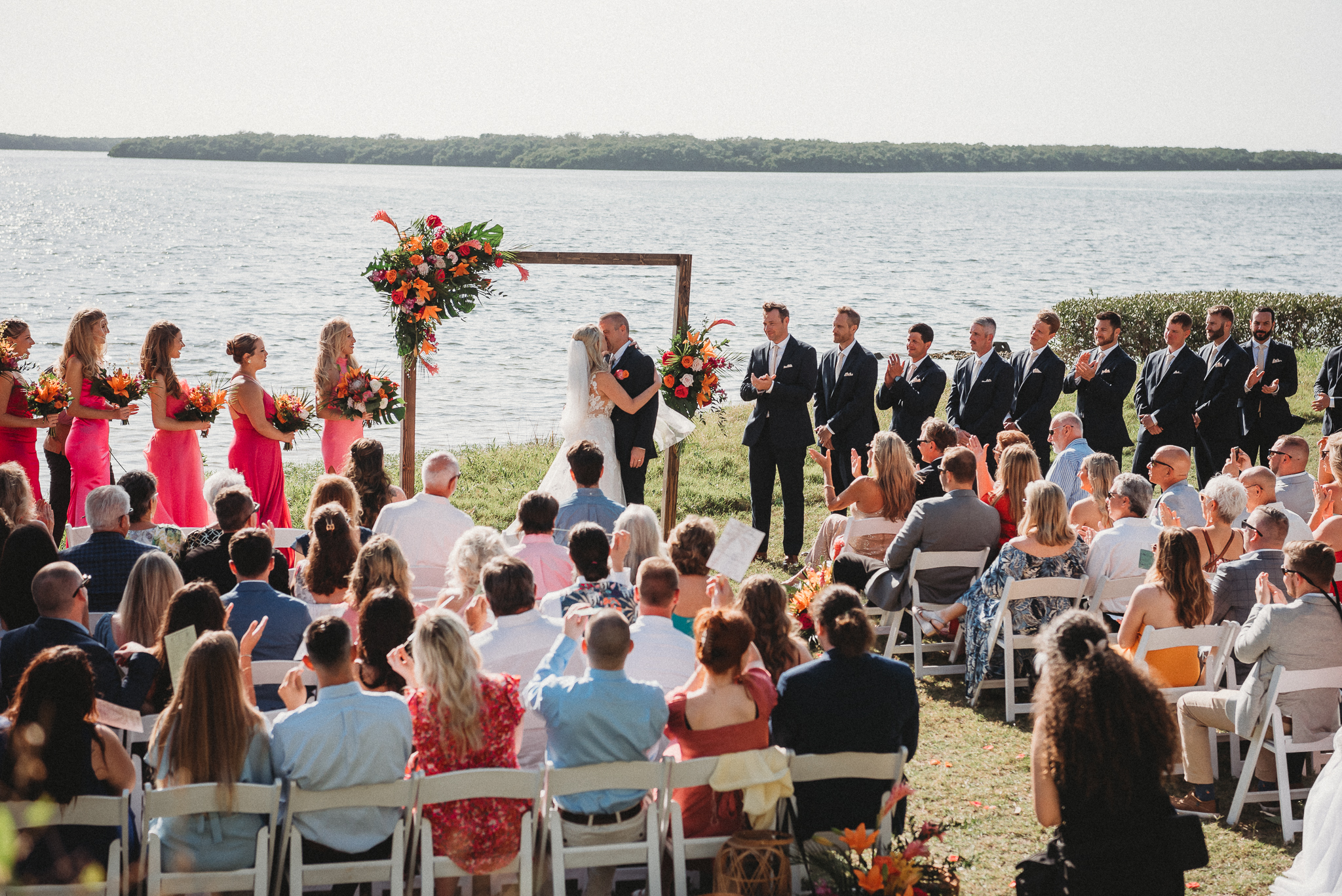Waterfront wedding ceremony at Tampa Bay Watch in St. Petersburg, Florida overlooking Tampa Bay. bride and Groom first kiss.