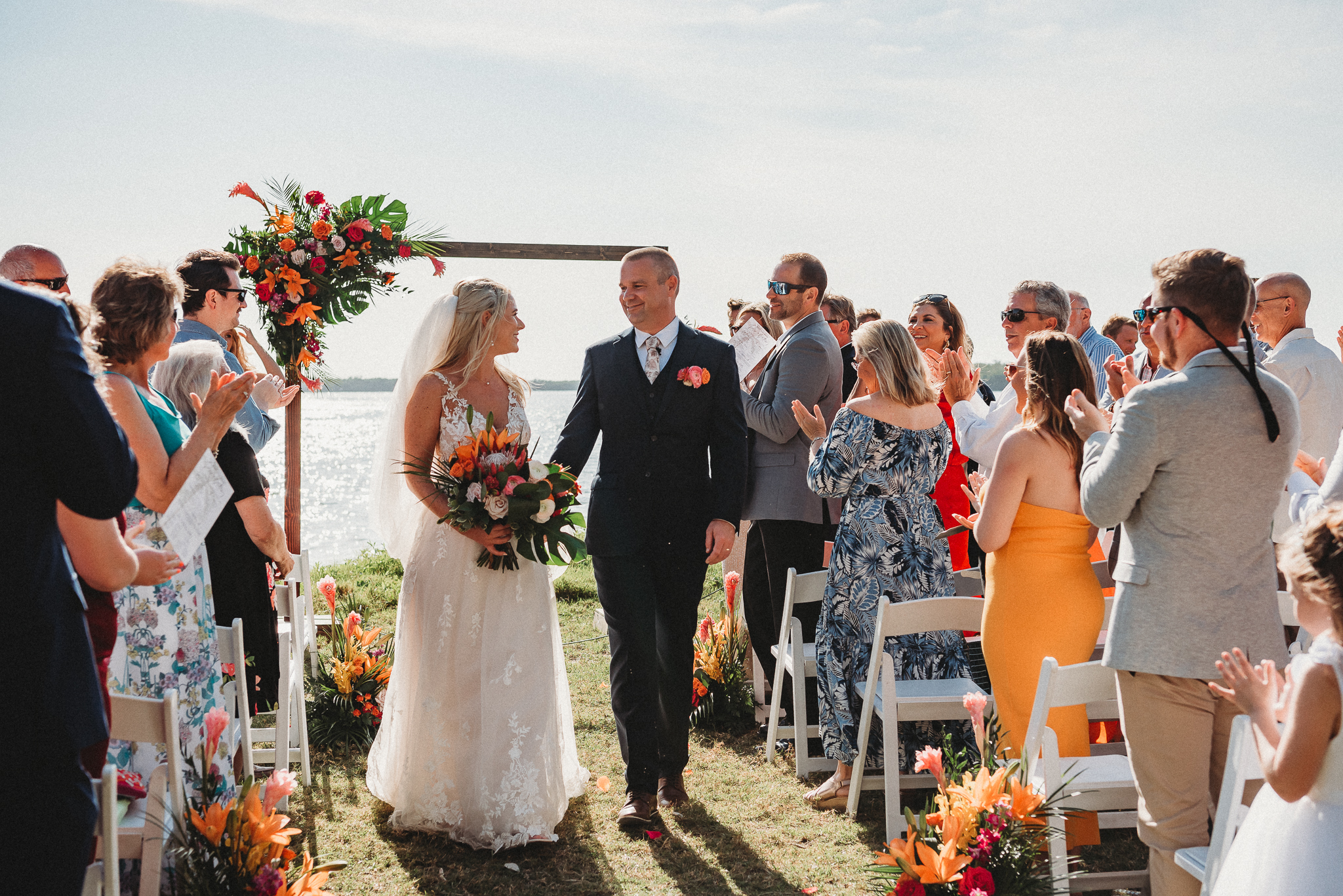 Bride and Groom walking down the aisle during a colorful Tampa Bay Watch outdoor ceremony