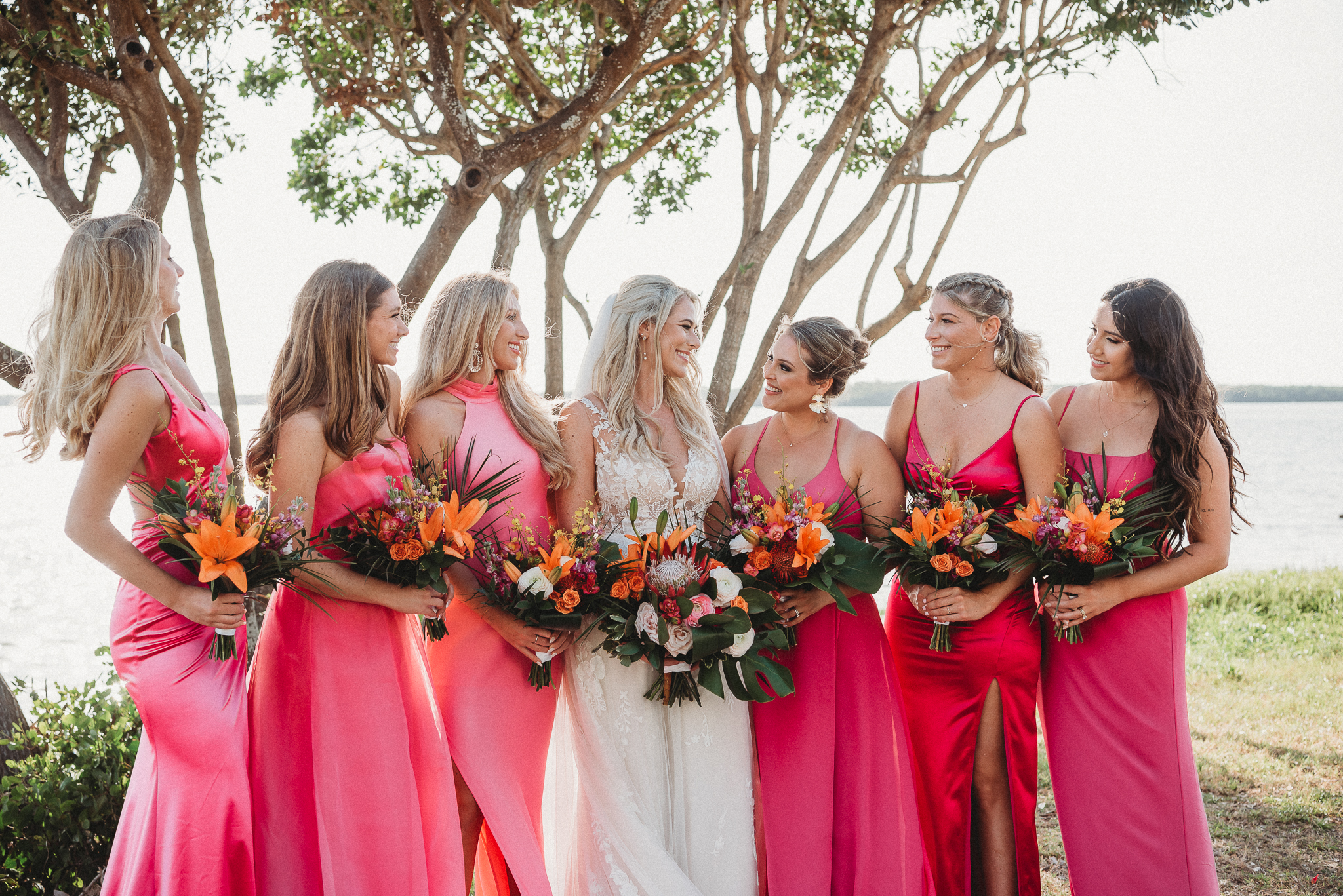 Bright bridesmaid dresses adding color to a Florida waterfront wedding. Fun Bridal Party Portraits