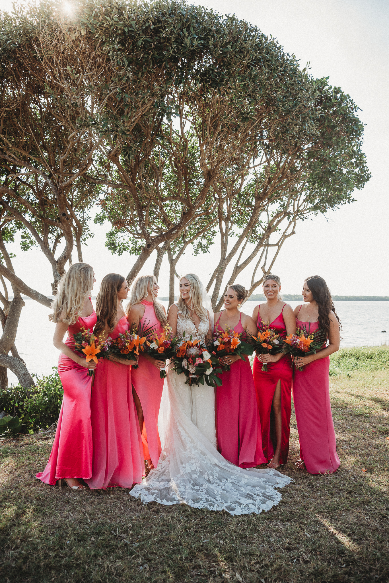 Bright bridesmaid dresses adding color to a Florida waterfront wedding. Fun Bridal Party Portraits