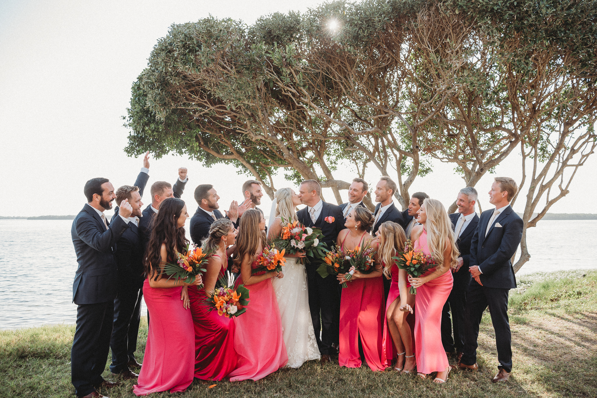 Bright bridesmaid dresses adding color to a Florida waterfront wedding. Fun Bridal Party Portraits