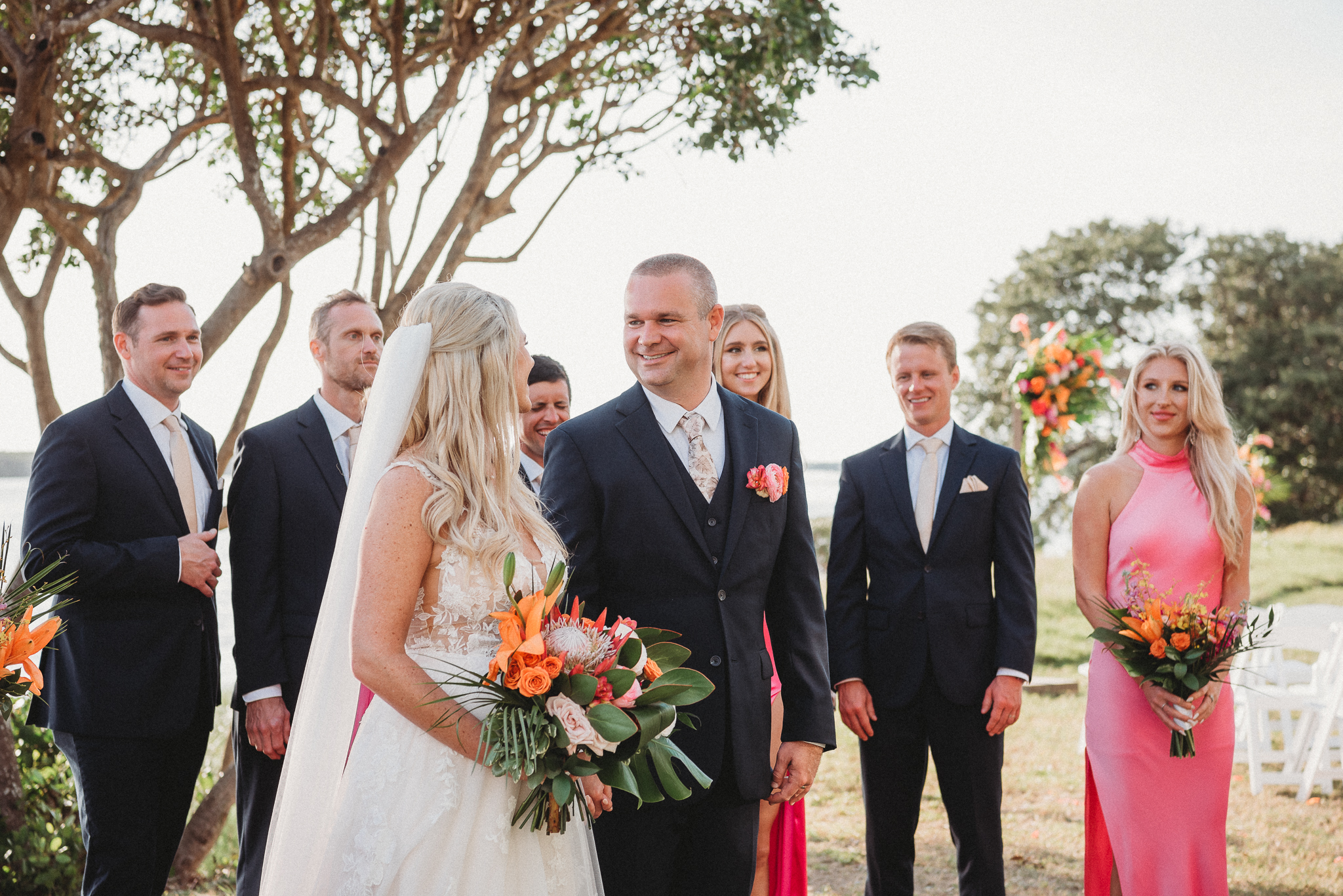 Bright bridesmaid dresses adding color to a Florida waterfront wedding. Fun Bridal Party Portraits