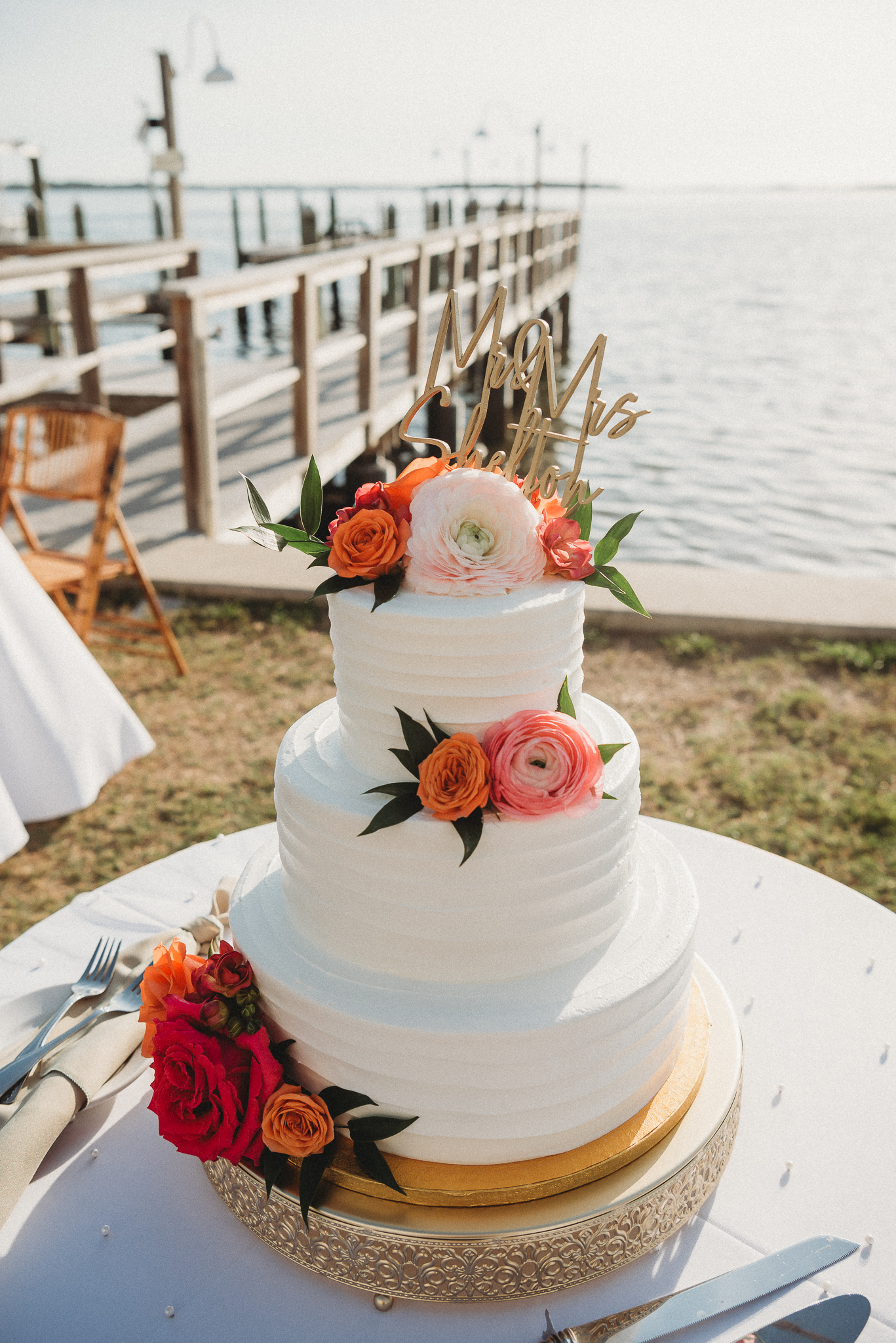 Elegant waterfront wedding cake with vibrant floral details on Florida’s Gulf Coast