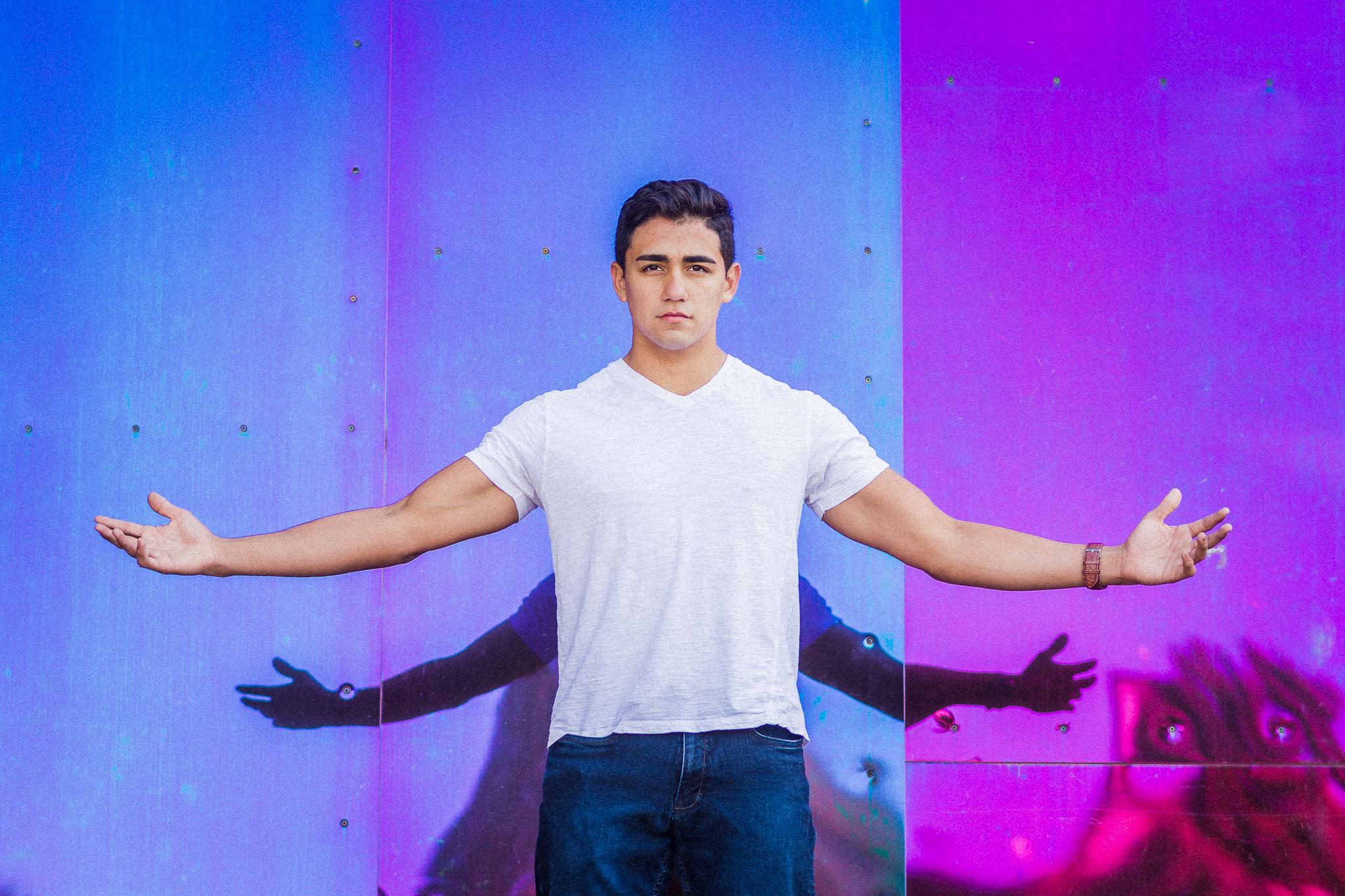 Urban senior portraits with colorful mural wall and modern street-style fashion