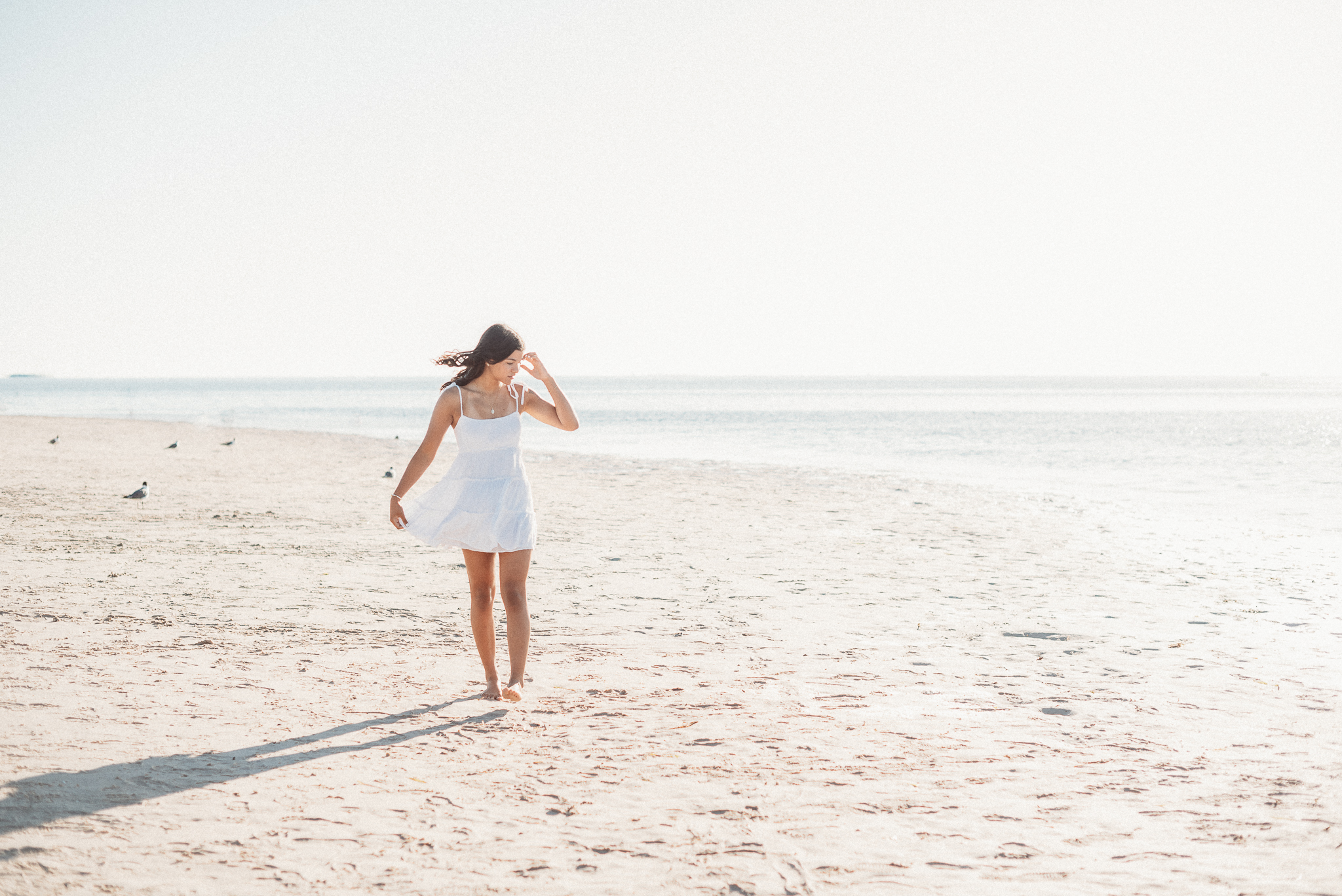 Florida senior photos on the beach with soft sunset light and ocean breeze